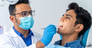 Metallic Taste in Your Mouth? Causes and When to See a Dentist 2 dentist evaluating patient with metallic taste in mouth in Crystal Lake