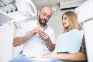 How Long Do Dental Implants Last? What to Expect from Start to Finish 3 How Long Do Dental Implants Last? What to Expect from Start to Finish | dentist explaining dental hygiene female patient | Family Dentistry of Crystal Lake