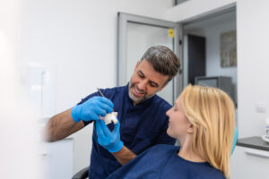 Can a Tooth or Dental Implant Break? How to Protect Your Smile Long-Term 3 Doctor explaining step by step how dental implants function during a consultation.