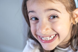Dental Cleaning for Children in Crystal Lake: Why Early Visits Matter 2 Little happy kid girl at dentist office smiling showing overbite teeth, child during orthodontist visit and oral cavity check-up, children tooth care and hygiene.