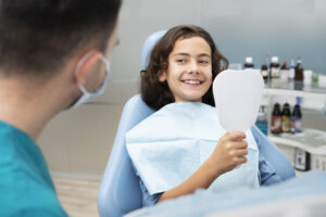 Dental Cleaning for Children in Crystal Lake: Why Early Visits Matter 1 Smiling child sitting comfortably in a dental chair with a friendly dentist