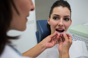 How Long Does Invisalign Take? A Clear Timeline for Straighter Teeth 2 Dentist assisting a patient to wear orthodontic silicone invisible braces