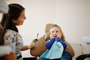Your Child’s First Dental Visit in Crystal Lake: What Parents Should Expect 1 Young child smiling during friendly pediatric dental appointment with dentist