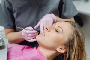 What Does a Dental Implant Look Like Before the Crown Is Placed? 1 Dental patient undergoing an implant follow-up appointment while a dentist examines the healing treatment area.