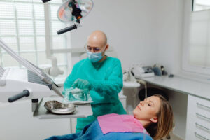 What Are Screwless Dental Implants? A Guide to This Modern Technology 2 Dentist preparing for a dental implant procedure while evaluating a patient's suitability for implant treatment.