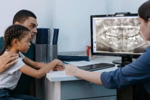 Dentist Near Huntley, IL: How to Find the Right Dental Care for Your Family 1 Family discussing dental X-rays and treatment options with a dentist during a comprehensive dental consultation near Huntley.