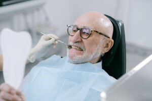 Dental Implants vs Dentures: Which Is Right for You? 1 Older patient reviewing denture treatment options with a dentist during a restorative dental consultation.
