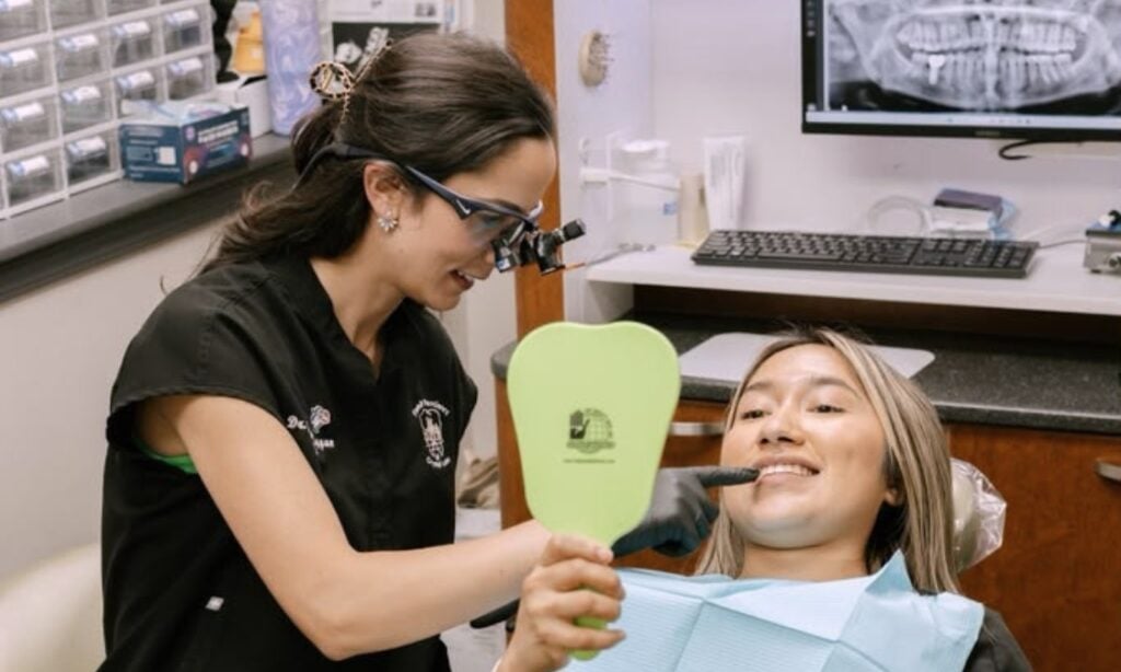 Dentist helping a patient view her smile in a hand mirror after a dental examination at Family Dentistry of Crystal Lake