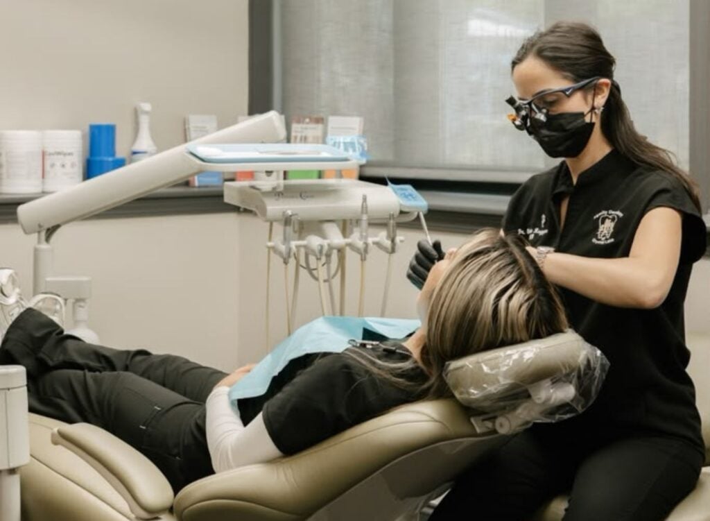 Family dentist holding a dental model while explaining oral health and proper dental care