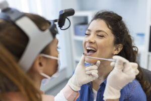 How Long Does a Dental Bridge Last? Tips to Extend Its Lifespan 2 Dentist examining a patient's dental bridge during a routine checkup.