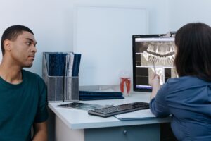 Emergency Dentist Near Me: When to Seek Immediate Dental Care 1 Patient holding their jaw in discomfort at a dental office reception desk.