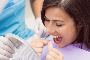 Broken or Chipped Tooth: What to Do Right Away (Same-Day Emergency) 2 Female patient flossing her teeth during a dental visit.