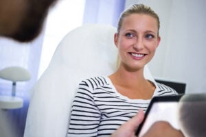 Cosmetic Dentistry in Crystal Lake: Veneers, Whitening & Bonding Explained 2 Dentist taking a dental X-ray of a female patient during an exam.